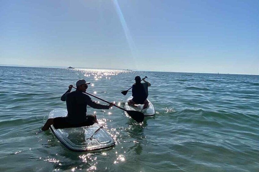 Two people kayaking on a calm sea with a clear sky. 5