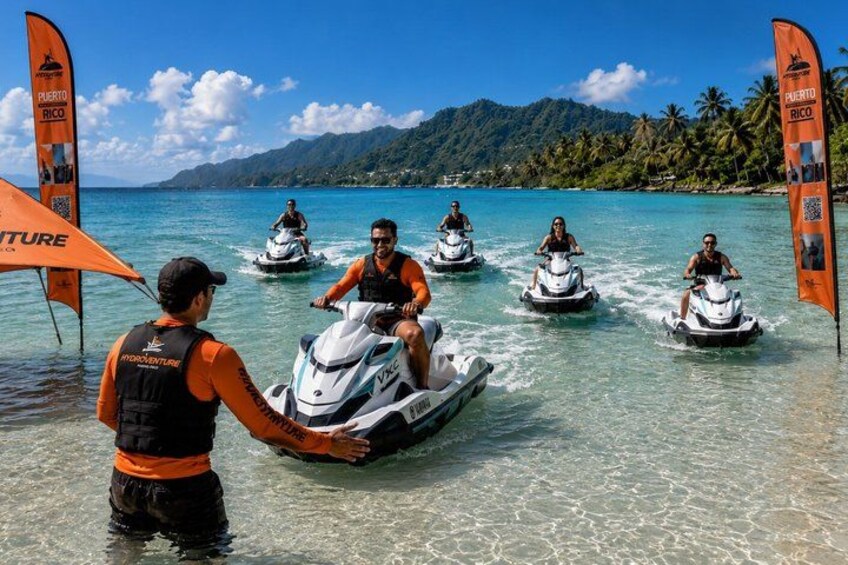 People jet-skiing on clear turquoise water with a tropical landscape in the background. 5