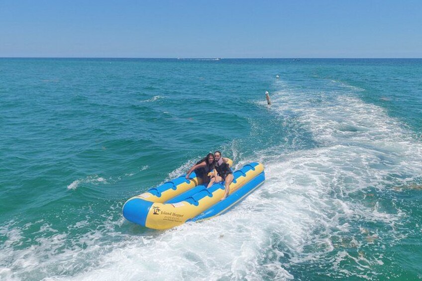 A blue and yellow inflatable raft with two people on the water. 2