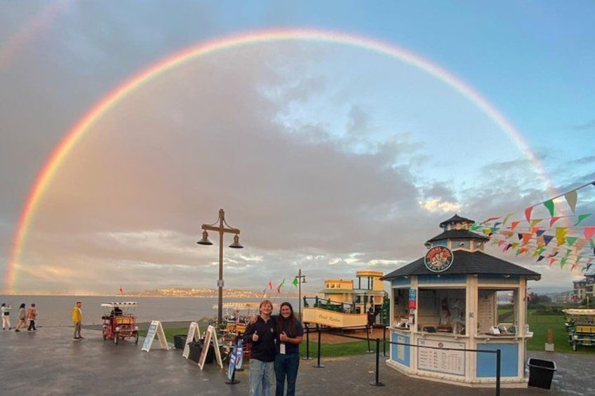 A beach with a rainbow, a gazebo, and a food kiosk. 4
