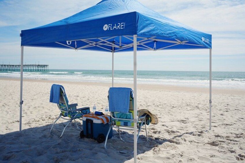 A beach with a blue tent labeled 'FLARE' and two beach chairs. 4