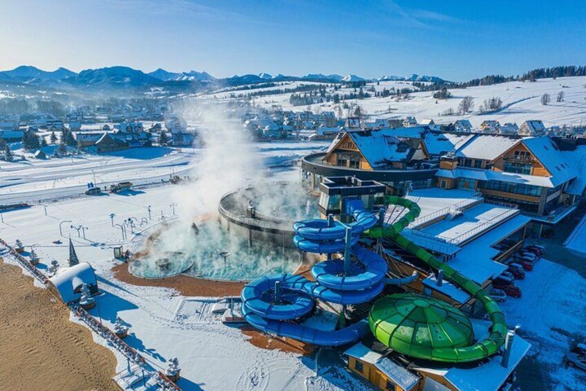 A water park with a geyser, water slides, and buildings. 3