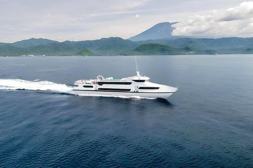 A white yacht on calm blue water with mountains in the background. 4