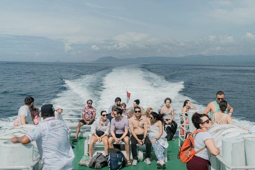 A group of people on a boat with a wake behind it, indicating movement through water. 3