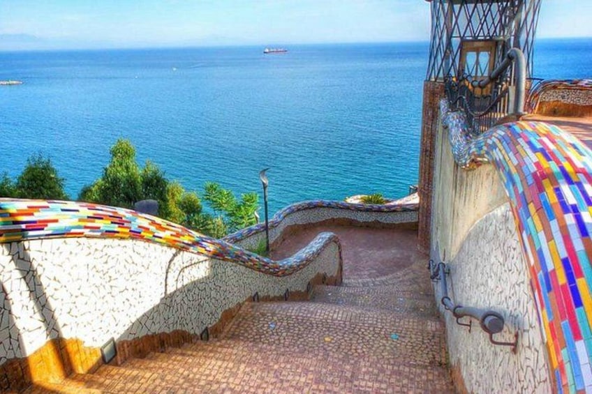 A staircase leading to a scenic overlook with a view of the sea. 3