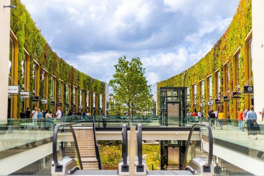 A modern shopping mall with a glass bridge and escalators. 5