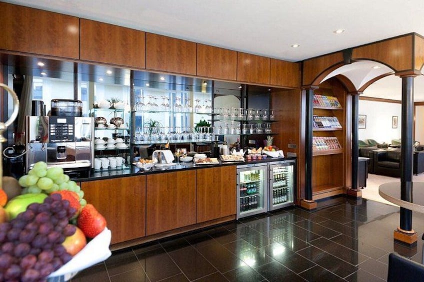 A modern kitchen with wooden cabinets, a coffee machine, and a fruit display. 4