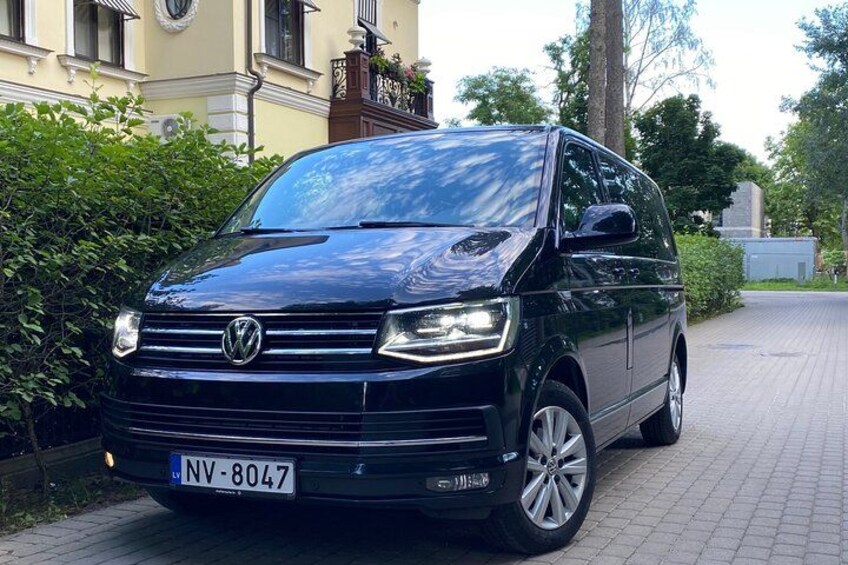 A black Volkswagen van parked on a paved driveway. 3