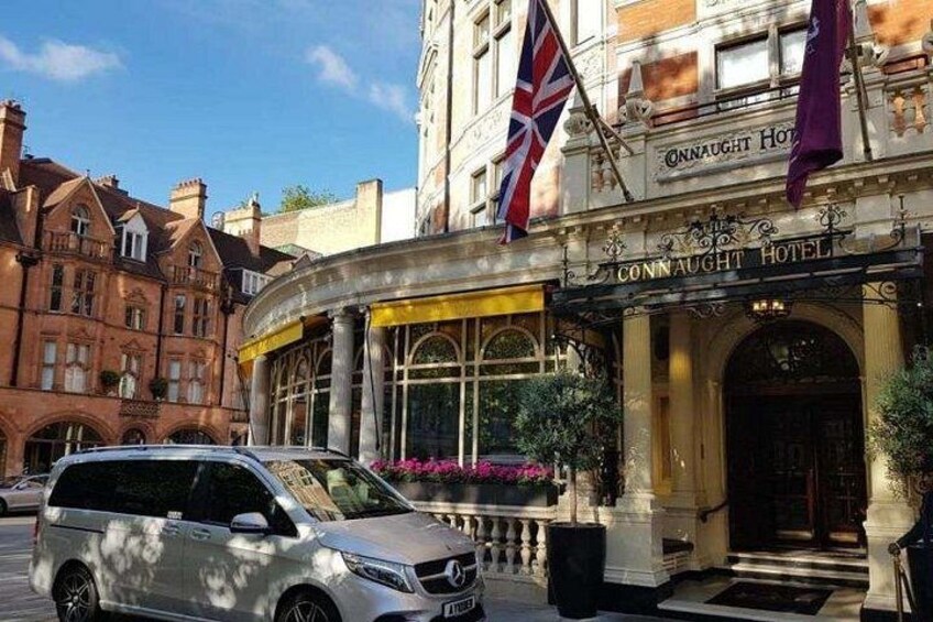 The Connaught Hotel with a flag, a car, and a building in the background. 1