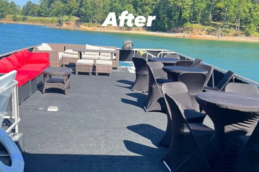 A boat deck with outdoor seating, a grill, and a view of a lake and trees. 4