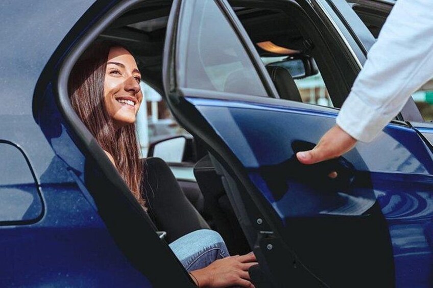 A person sitting in a car with the door open, another person reaching out to them. 5