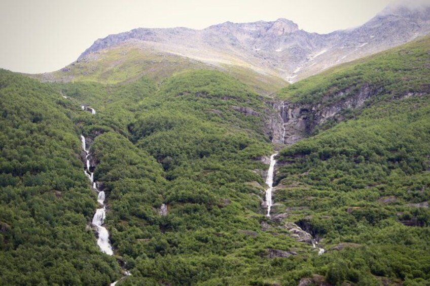 A mountainous landscape with two waterfalls cascading down the valley. 4