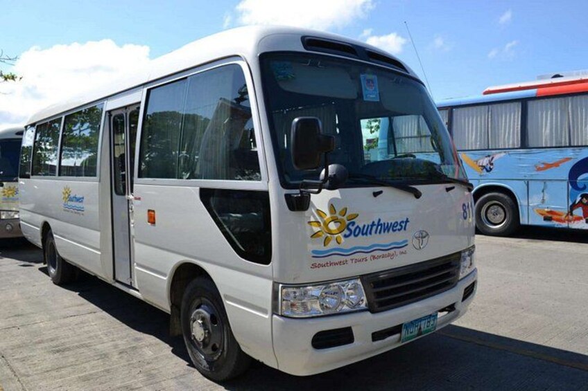 A white tour bus with 'Southwest Tours' branding parked in a lot. 3