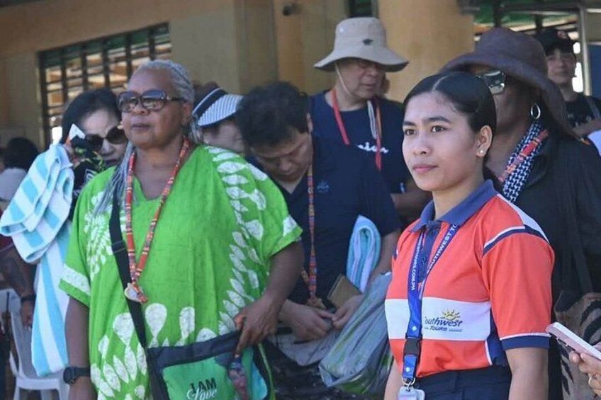 A group of people standing outdoors, some wearing lanyards and name tags. 4
