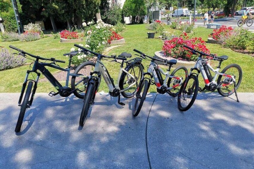 A row of bicycles parked on a concrete surface. 3