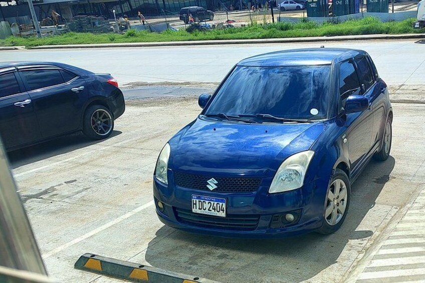A blue car parked on a street with a visible license plate. 4