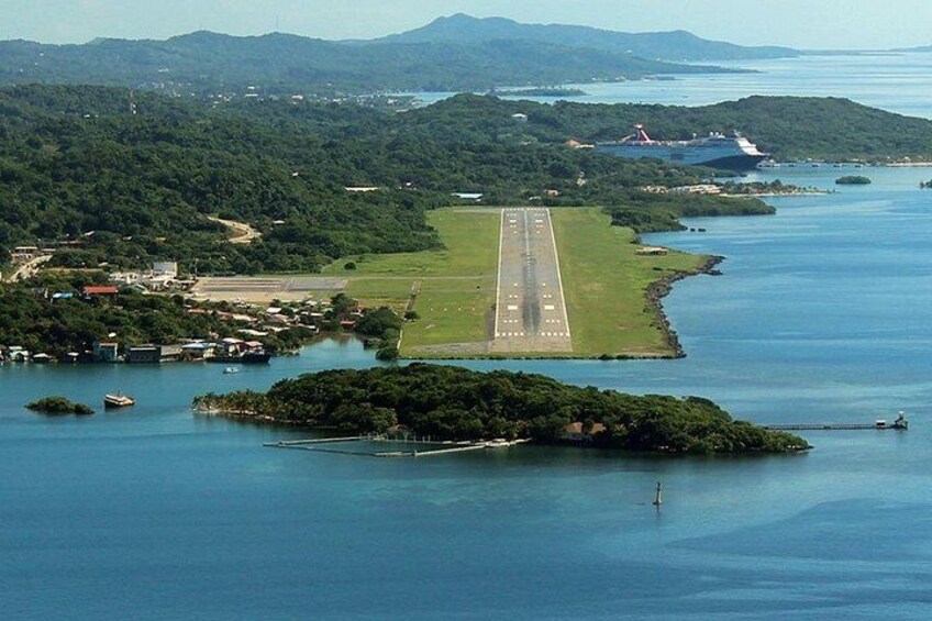 An airport runway surrounded by water and greenery. 3