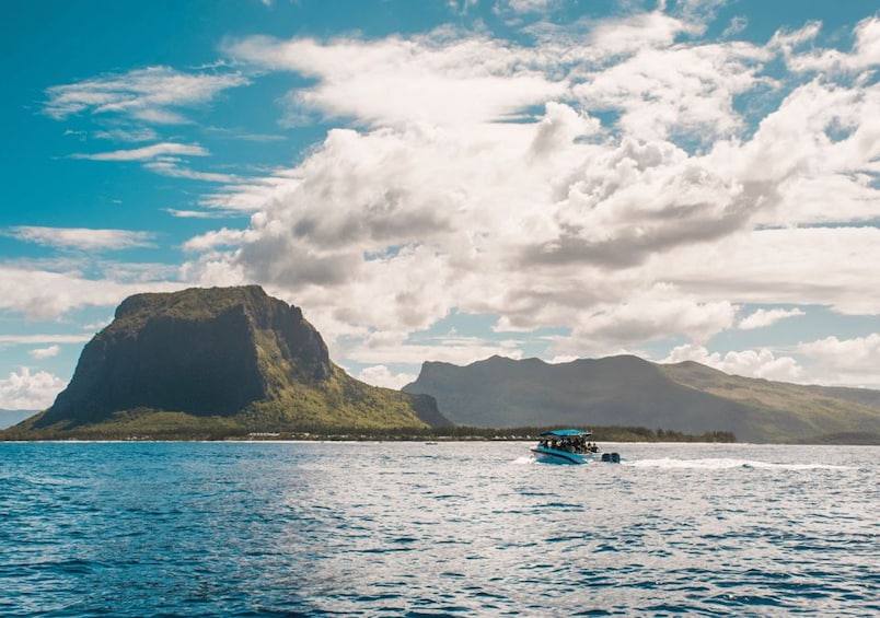 A boat on a calm sea with a mountainous island in the background. 2