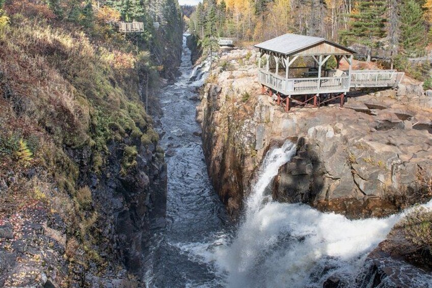 A waterfall, a rocky riverbank, and a wooden viewing platform. 4