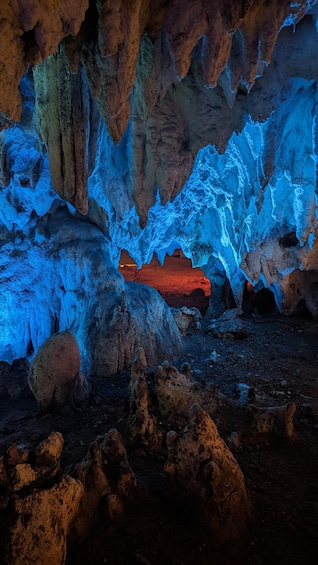 Una cueva con iluminación azul y formaciones rocosas rojas. 1