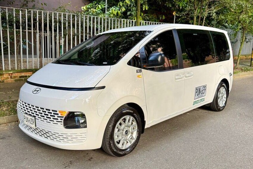 A white minivan parked on a street with a license plate PU-639. 5