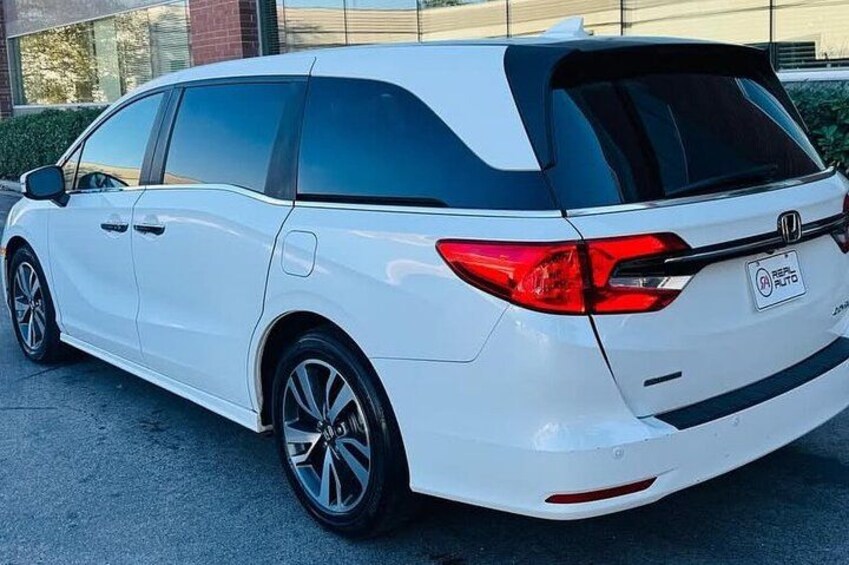 A white Honda minivan parked outdoors. 4