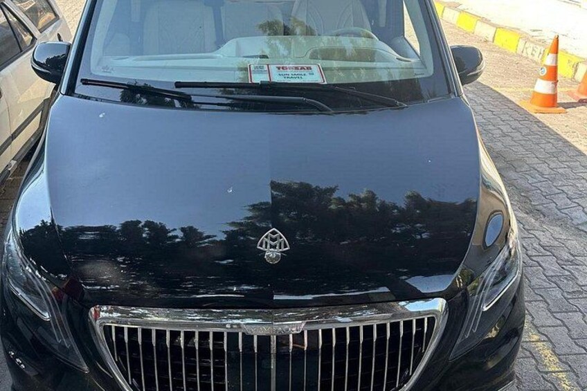 A black car with a visible license plate and a logo on the hood. 2