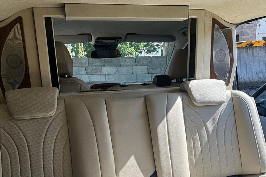A vehicle interior with beige leather seats and a sunroof. 5