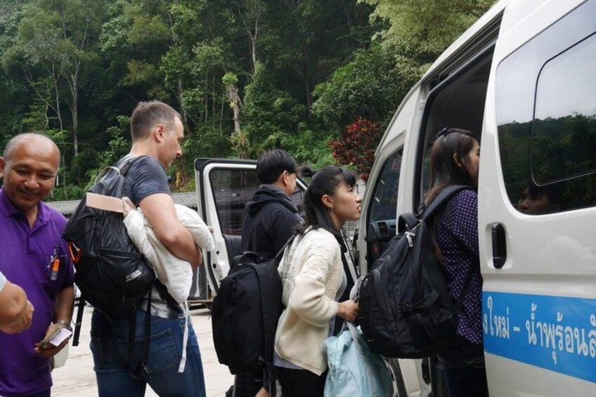 People boarding a white van with blue text. 4