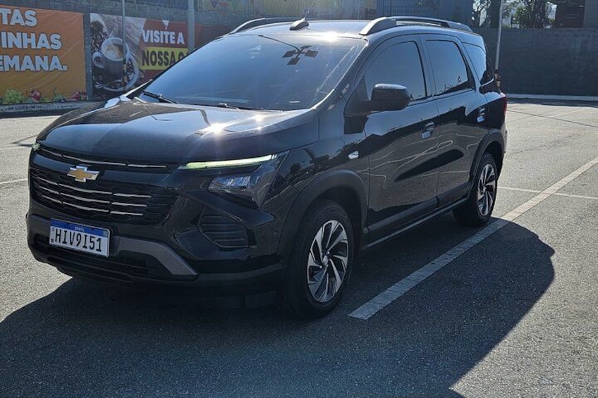 A black Chevrolet SUV parked on a street with a visible license plate. 1