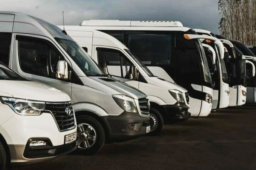 A row of white and black vehicles parked in a lot. 5