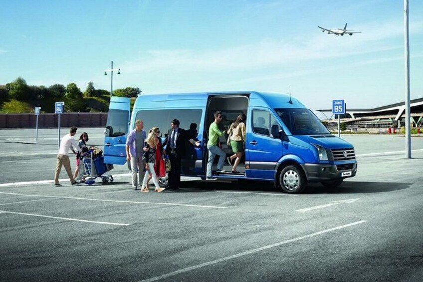 A blue van with passengers exiting, a parking lot, and an airplane in the background. 3
