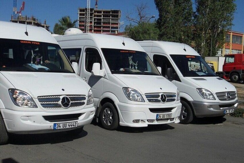 Three white Mercedes-Benz vans parked in a row on a street. 4