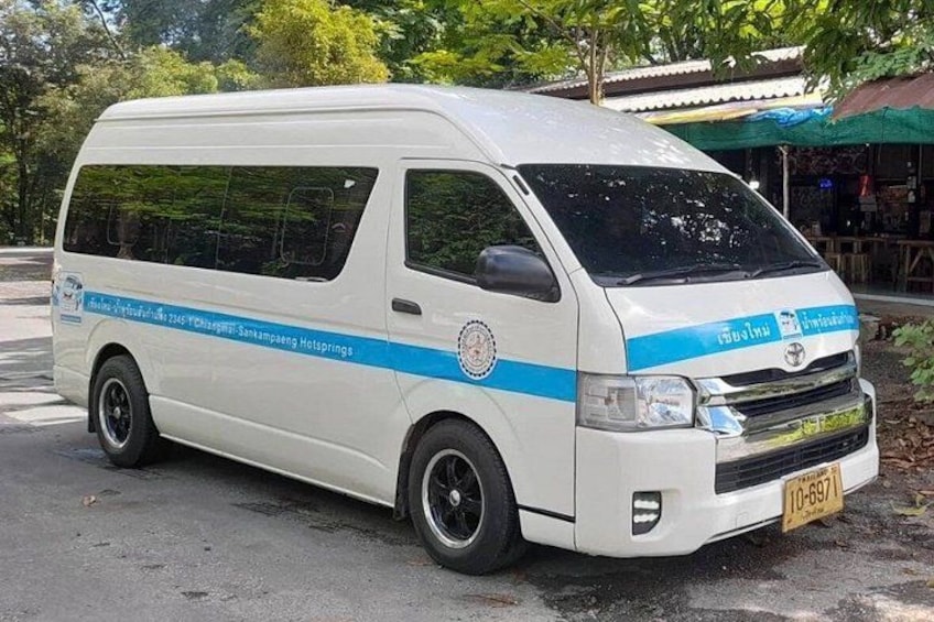 A white van with blue stripes parked on a street. 1