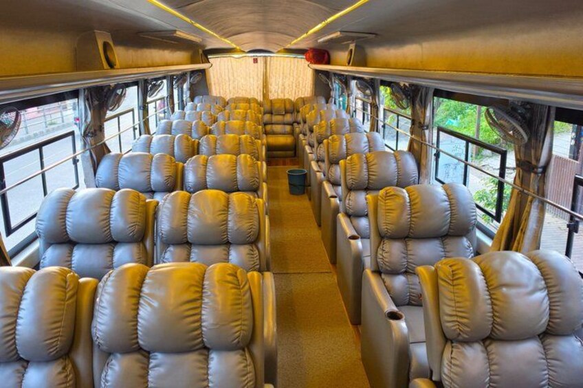 A train interior with rows of leather seats, windows, and overhead luggage compartments. 3