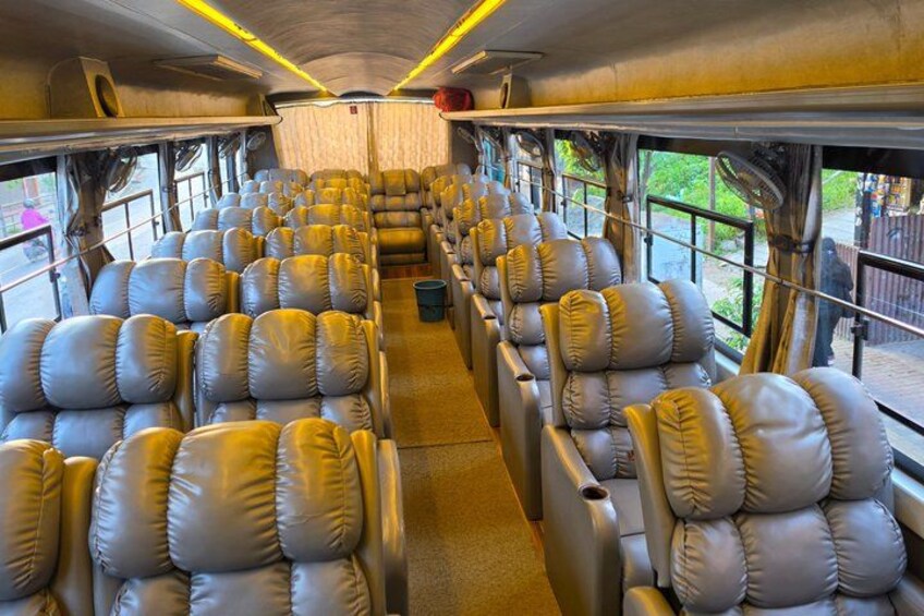A train interior with rows of leather seats and windows. 4