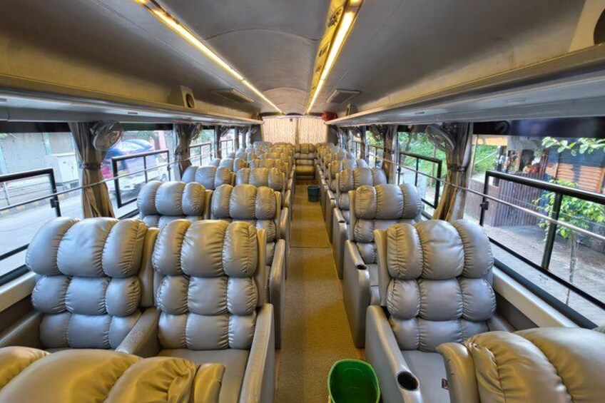 A train interior with leather seats, windows, and overhead luggage racks. 5