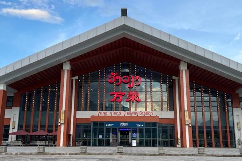 A modern building with large glass windows and a prominent red sign. 3