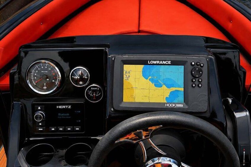 A dashboard with a Lowrance GPS device, a HERTZ radio, and a steering wheel. 3