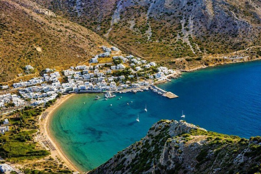 A coastal village with buildings, a beach, and boats. 2