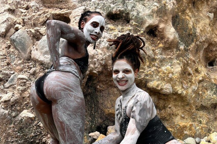 Two people with white paint on their bodies sitting on rocks. 3