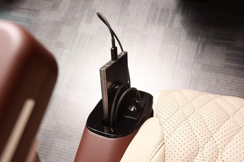 A charging station with a cable and a device, placed on a surface with a patterned cushion. 4