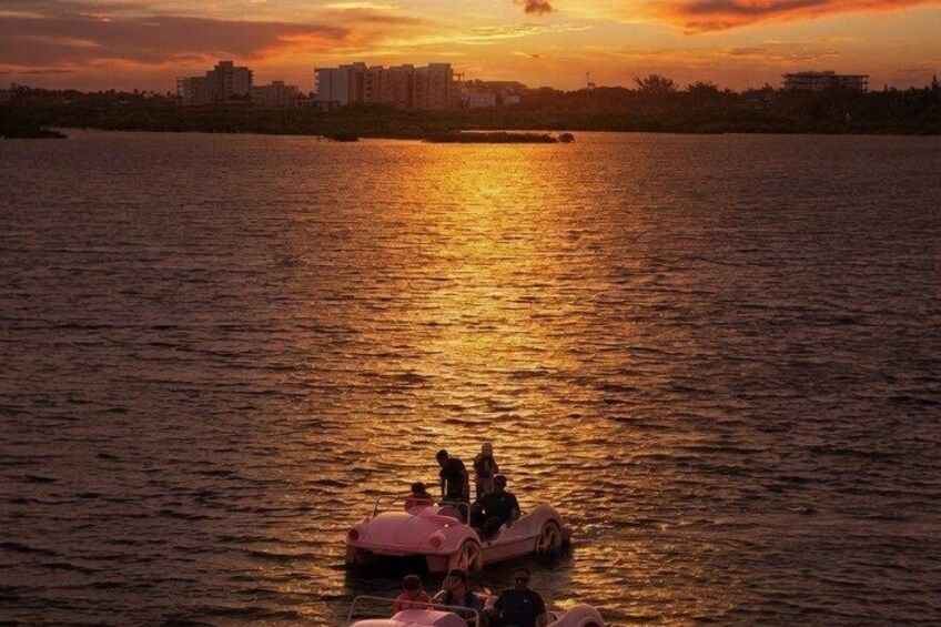 A sunset over a body of water with a boat and people on it. 3