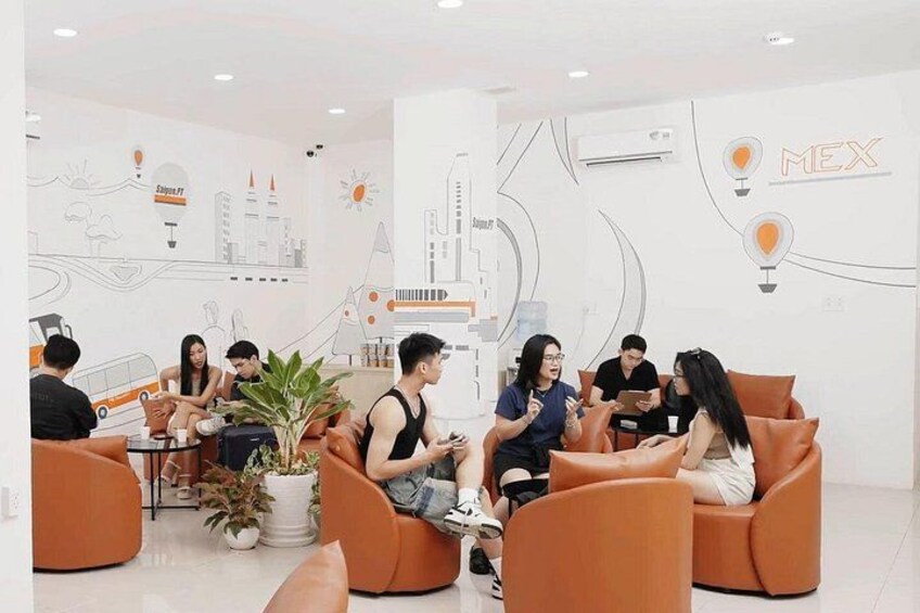 A modern lounge with orange seating, a cityscape mural, and a sign reading 'MEX'. 3