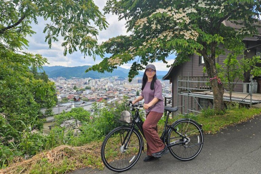 A person on a bicycle with a cityscape in the background. 3