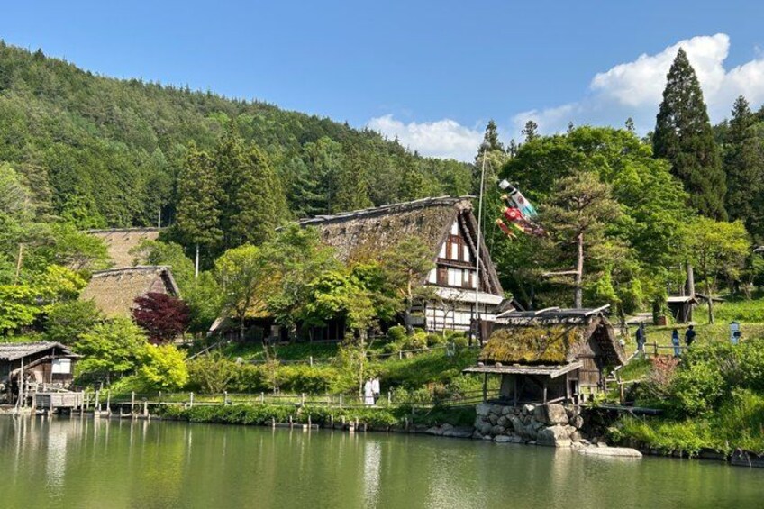 A traditional Japanese village by a lake with wooden houses and a large pagoda. 2