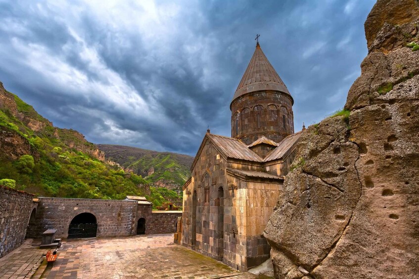 Una iglesia histórica con un campanario, ubicada frente a montañas bajo un cielo nublado. 5