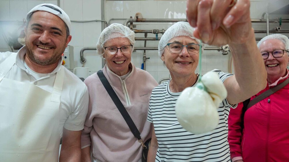 Cuatro personas en una cocina, una sosteniendo un vegetal blanco. 1