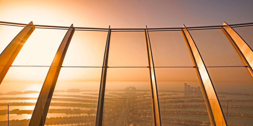 A panoramic view from a high vantage point, featuring a cityscape with a river, buildings, and a sunset. 2