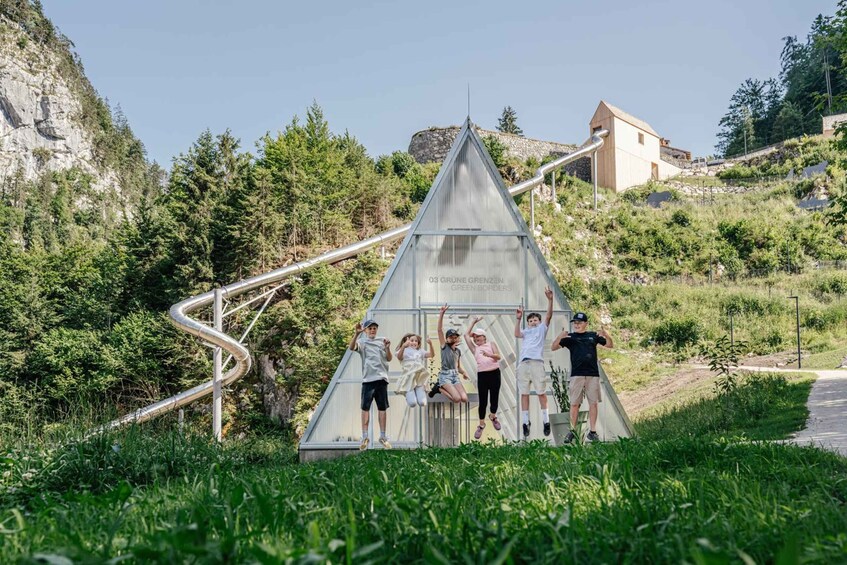 Un groupe de personnes saute sur une structure triangulaire, près d’un toboggan en métal. 4